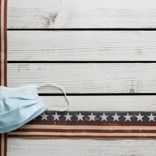 Face mask resting on white wooden boards with a stars-and-stripes border